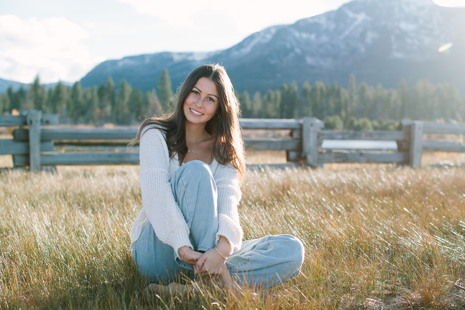High school senior barefoot on Lake Tahoe beach at sunset
